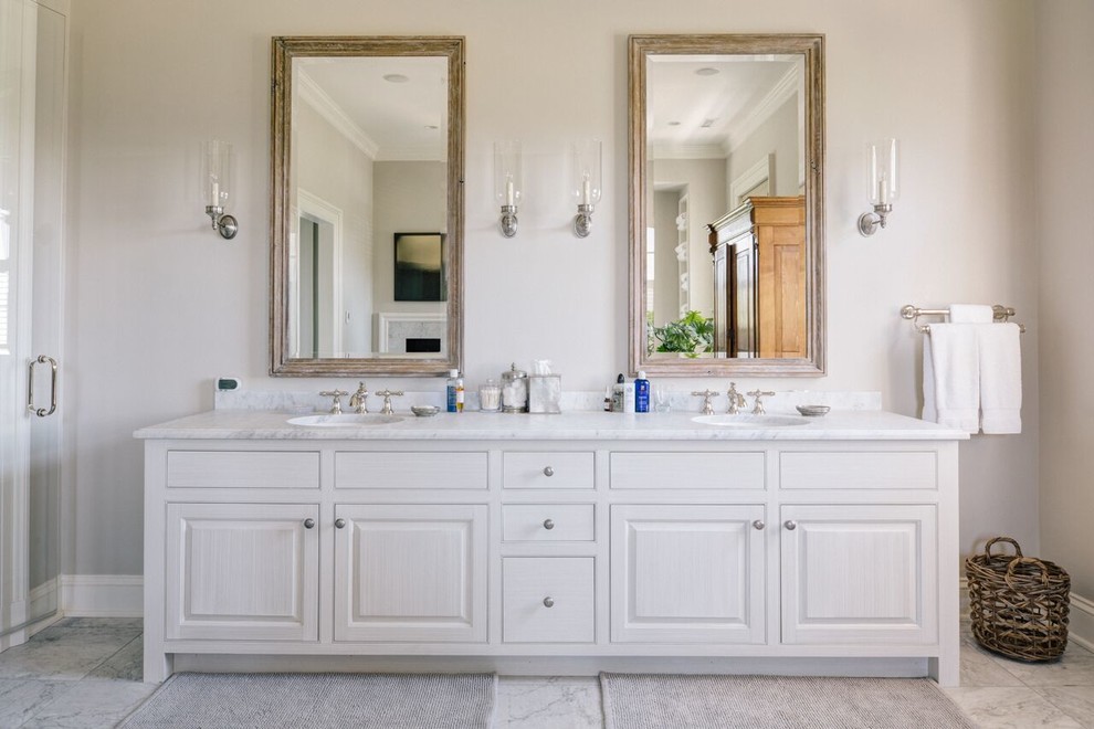 Пример оригинального дизайна: огромная ванная комната в стиле неоклассика (современная классика) с фасадами с выступающей филенкой, белыми фасадами, серыми стенами, врезной раковиной, накладной ванной, душем в нише, раздельным унитазом, серой плиткой, белой плиткой, каменной плиткой, мраморным полом, мраморной столешницей, серым полом и душем с распашными дверями