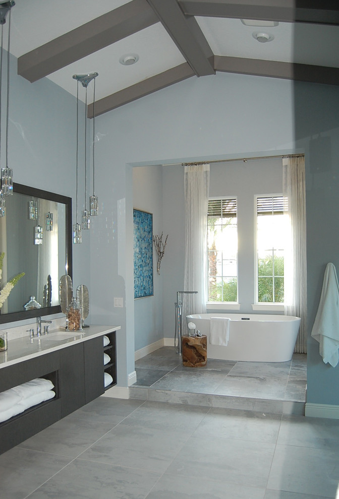 На фото: ванная комната в стиле неоклассика (современная классика) с плоскими фасадами, серыми фасадами, отдельно стоящей ванной, синими стенами и серым полом