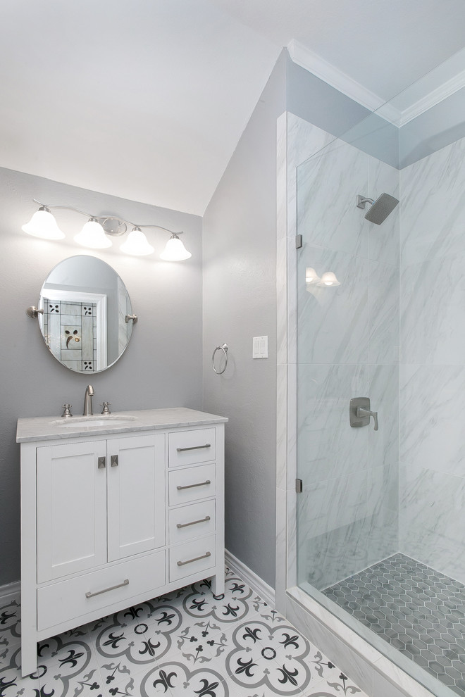 Modern inredning av ett litet grå grått badrum med dusch, med porslinskakel, grå väggar, dusch med gångjärnsdörr, skåp i shakerstil, vita skåp, grå kakel, vit kakel, marmorbänkskiva, en hörndusch, cementgolv, ett undermonterad handfat och flerfärgat golv