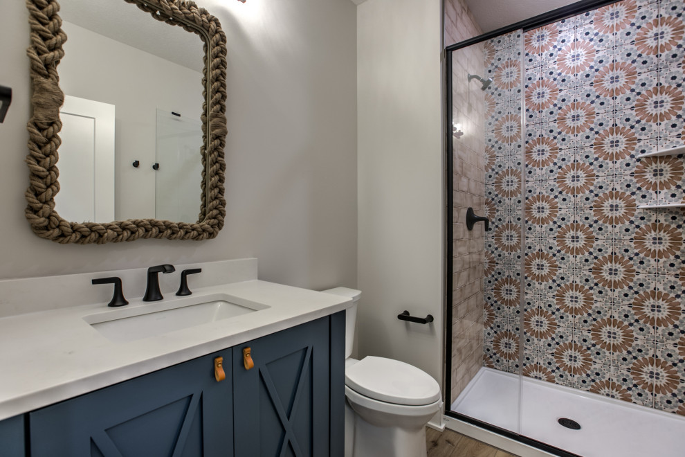 Example of a transitional 3/4 cement tile single-sink alcove shower design in Omaha with a one-piece toilet, an undermount sink, quartz countertops, a hinged shower door, white countertops, a built-in vanity and recessed-panel cabinets