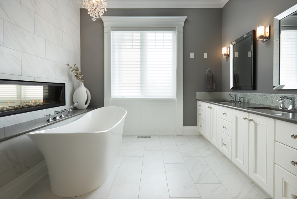 Idee per una stanza da bagno padronale classica con ante a filo, ante bianche, vasca freestanding, piastrelle bianche, pareti grigie, lavabo sottopiano e pavimento bianco