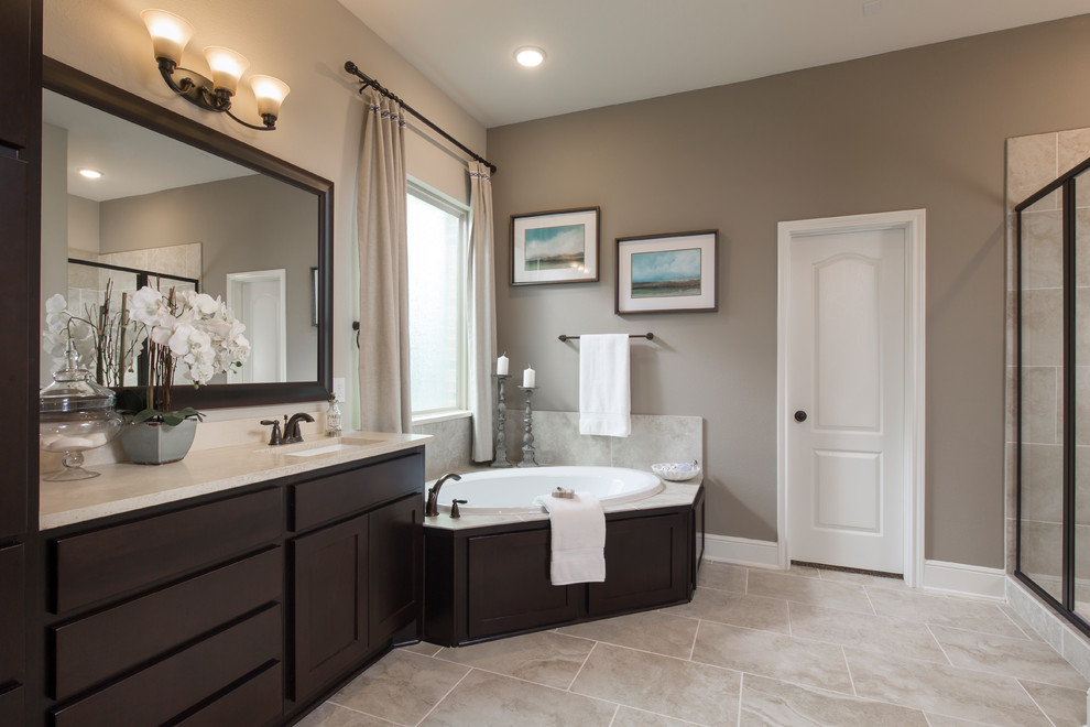 Bathroom - transitional master beige tile beige floor bathroom idea in Houston with shaker cabinets, dark wood cabinets, brown walls and beige countertops