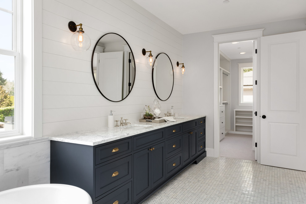 Design ideas for a medium sized traditional family bathroom in Los Angeles with shaker cabinets, blue cabinets, a shower/bath combination, a one-piece toilet, white walls, ceramic flooring, a built-in sink, engineered stone worktops, white floors, a hinged door, white worktops, double sinks, a freestanding vanity unit and tongue and groove walls.