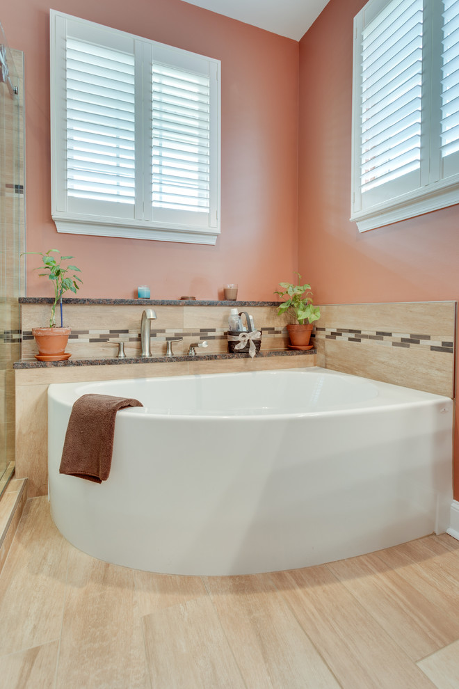 Immagine di una stanza da bagno padronale tradizionale di medie dimensioni con lavabo integrato, ante con riquadro incassato, ante in legno scuro, vasca ad angolo, doccia doppia, pareti grigie e parquet chiaro