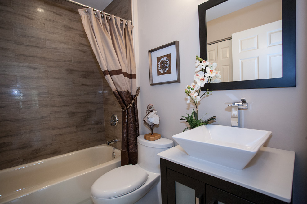 Example of a classic multicolored tile and porcelain tile bathroom design in Miami with a vessel sink, furniture-like cabinets, black cabinets, quartzite countertops and a one-piece toilet