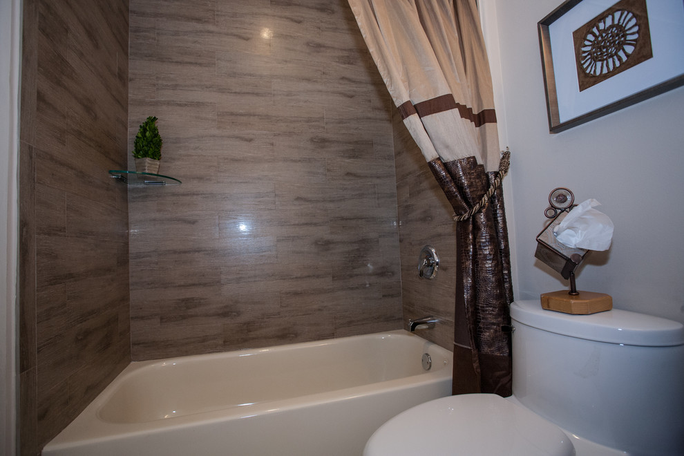 Example of a classic beige tile and porcelain tile bathroom design in Miami with a vessel sink, furniture-like cabinets, black cabinets, quartzite countertops and a one-piece toilet