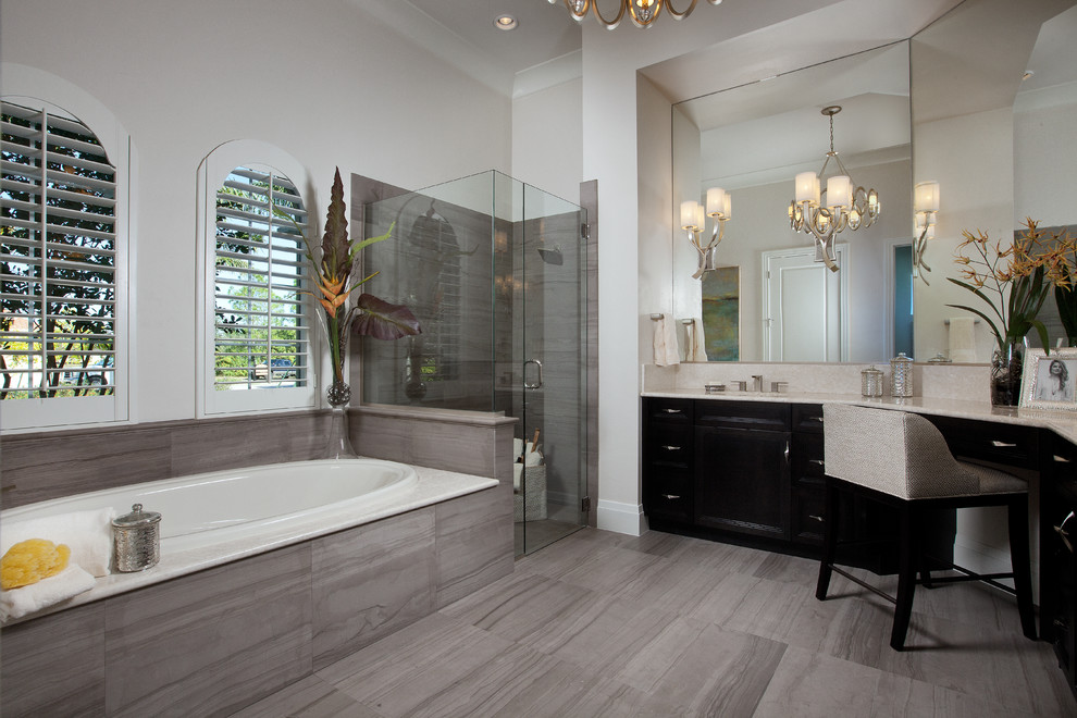 Aménagement d'une salle de bain classique avec des portes de placard noires, une baignoire posée, une douche d'angle et un carrelage gris.