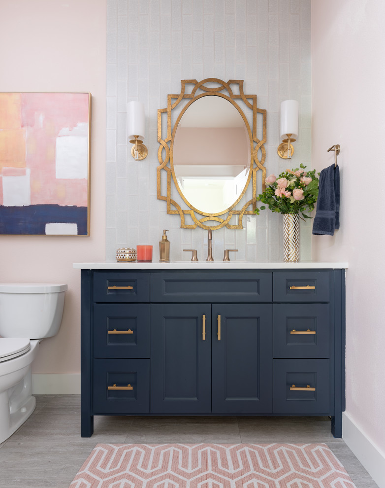 Стильный дизайн: ванная комната среднего размера в стиле неоклассика (современная классика) с синими фасадами, синей плиткой, стеклянной плиткой, розовыми стенами, душевой кабиной, врезной раковиной, столешницей из кварцита, белой столешницей, фасадами с утопленной филенкой, раздельным унитазом и серым полом - последний тренд