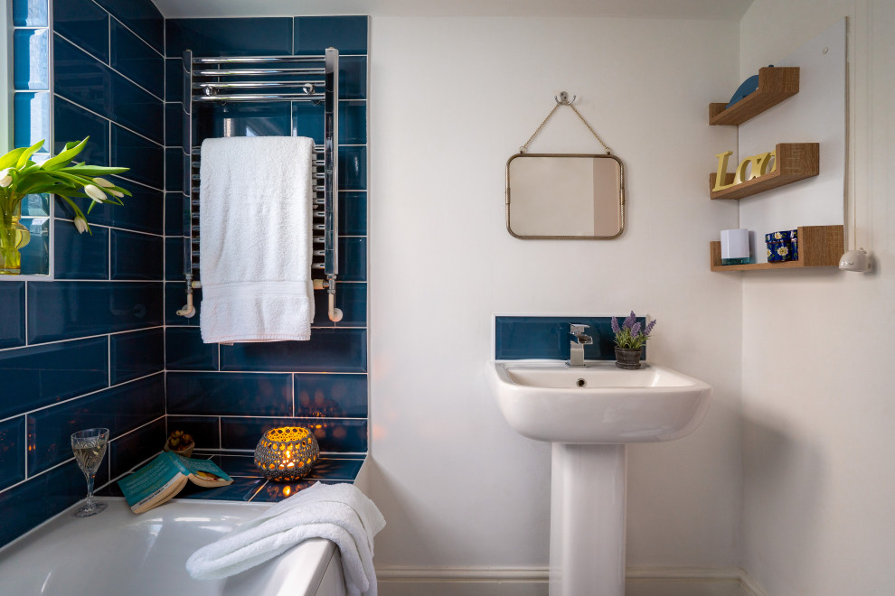 Kleines Klassisches Duschbad mit Duschbadewanne, blauen Fliesen, weißer Wandfarbe, Sockelwaschbecken, Einzelwaschbecken und eingebautem Waschtisch in Devon