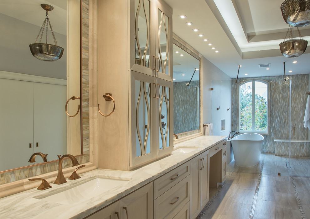 Large transitional master gray tile and porcelain tile porcelain tile bathroom photo in Houston with an undermount sink, furniture-like cabinets, white cabinets, a two-piece toilet, gray walls and marble countertops