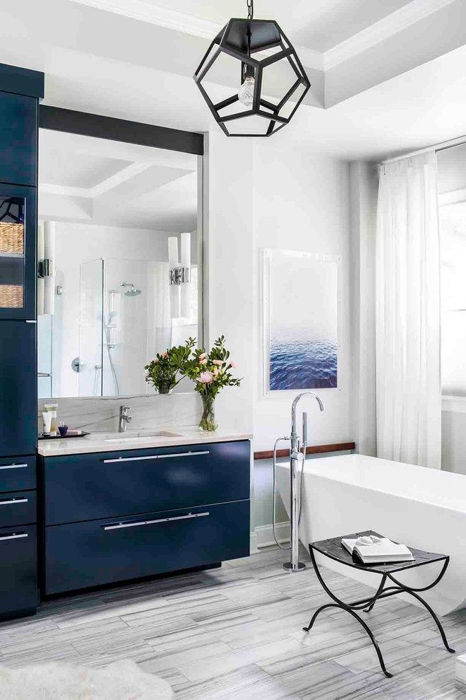 Klassisches Badezimmer En Suite mit flächenbündigen Schrankfronten, blauen Schränken, freistehender Badewanne, weißer Wandfarbe, Unterbauwaschbecken und Marmorboden in Atlanta