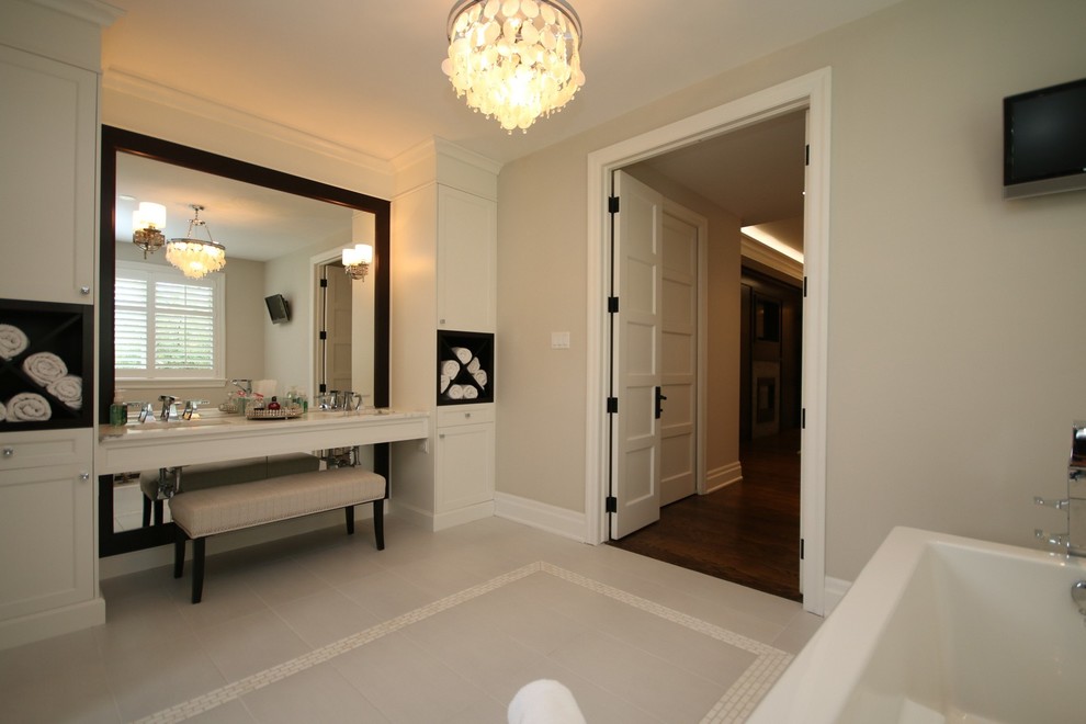 Mittelgroßes Klassisches Badezimmer mit weißen Schränken, Marmor-Waschbecken/Waschtisch, freistehender Badewanne, grauen Fliesen und beiger Wandfarbe in Ottawa