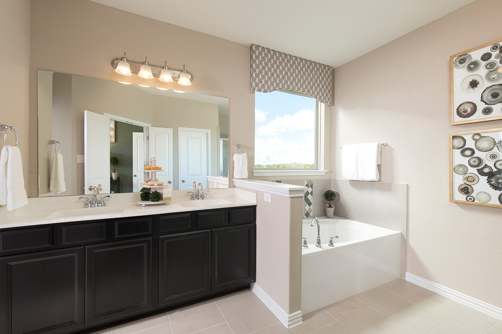 Photo of a traditional ensuite bathroom in Other with recessed-panel cabinets, an alcove bath, beige walls, a submerged sink, beige floors, white worktops and black cabinets.