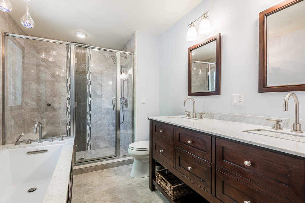 Exemple d'une douche en alcôve principale chic en bois foncé de taille moyenne avec un placard à porte shaker, une baignoire encastrée, WC séparés, un carrelage beige, un mur bleu, un sol en carrelage de céramique, un lavabo encastré et un plan de toilette en quartz modifié.