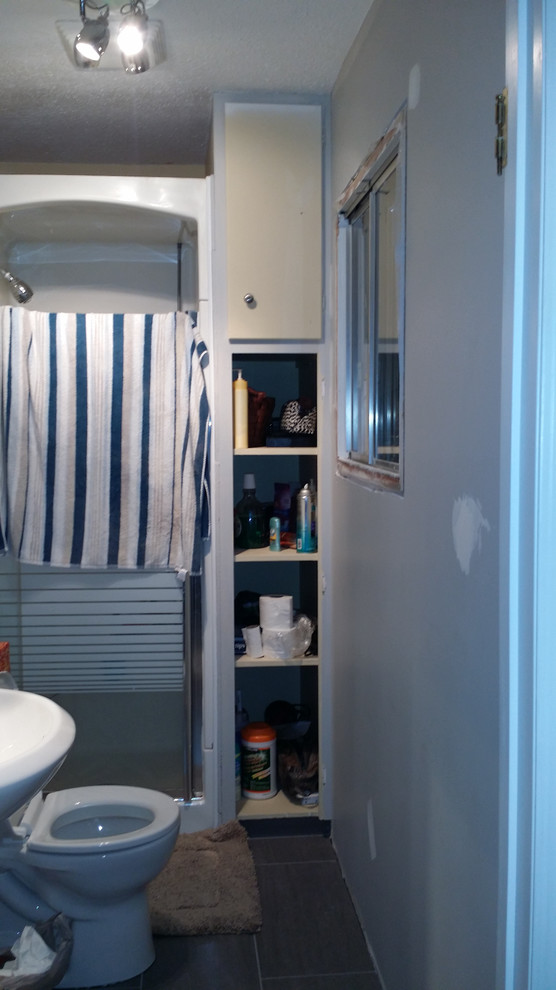 Ispirazione per una stanza da bagno con doccia chic di medie dimensioni con lavabo da incasso, ante con bugna sagomata, ante bianche, top in laminato, doccia alcova, WC a due pezzi e pareti grigie