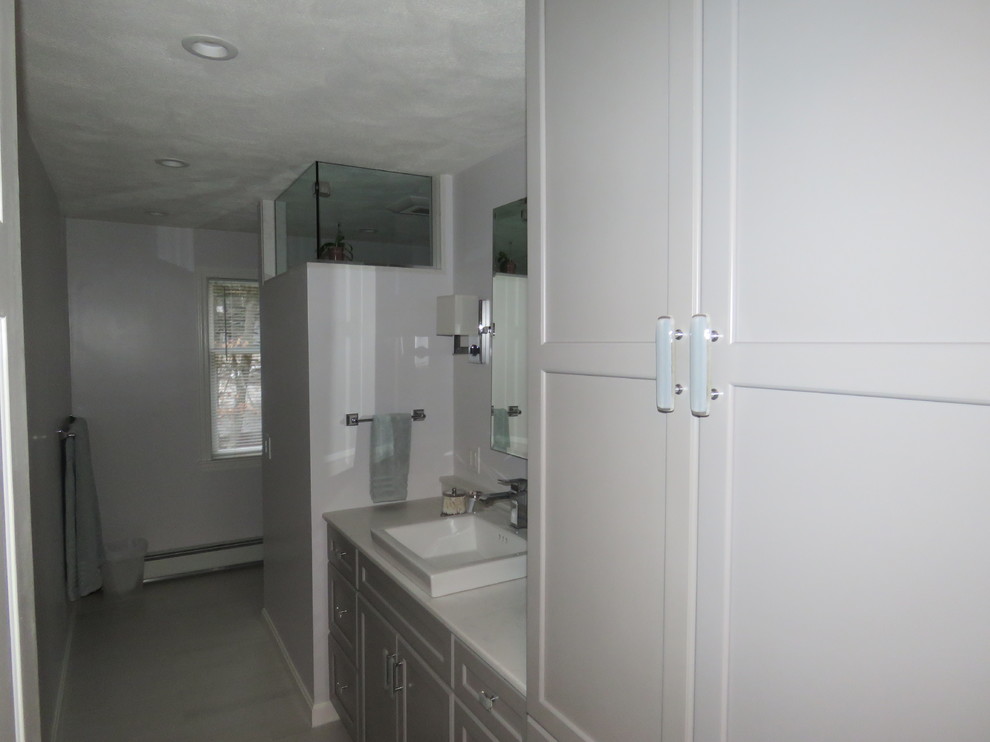 Diseño de cuarto de baño tradicional renovado de tamaño medio con armarios con paneles empotrados, puertas de armario grises, ducha empotrada, paredes grises, suelo de baldosas de porcelana, aseo y ducha, lavabo encastrado y encimera de mármol