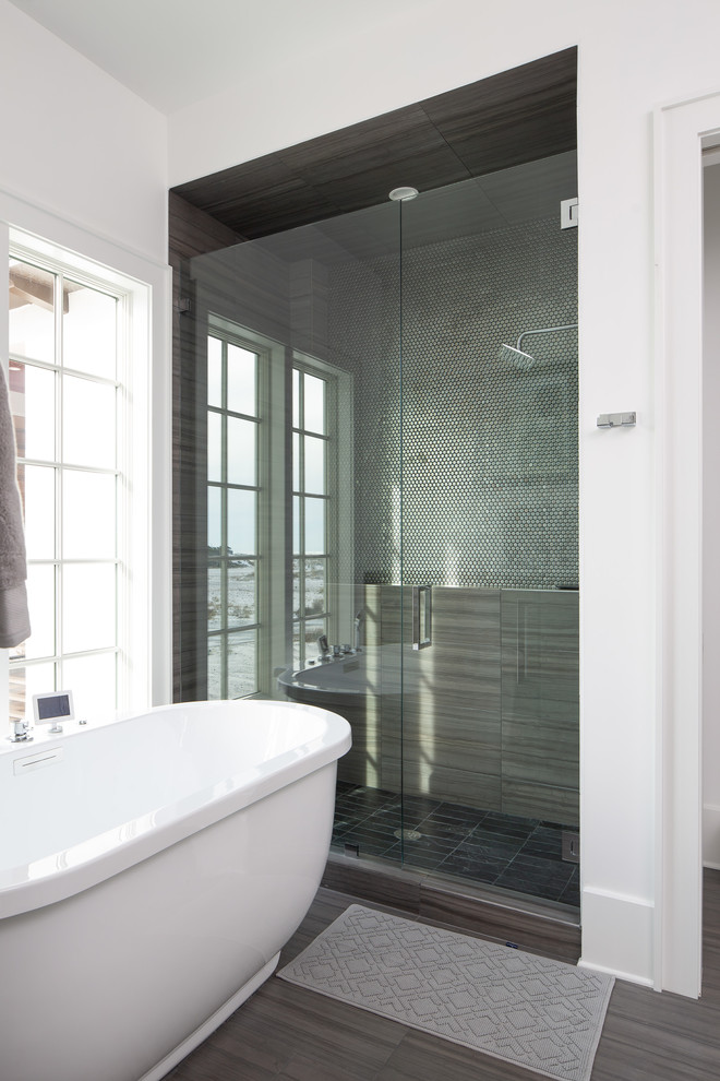 Maritim inredning av ett stort grå grått en-suite badrum, med luckor med infälld panel, ett fristående badkar, våtrum, vita väggar, mörkt trägolv, ett undermonterad handfat, brunt golv, dusch med gångjärnsdörr, bänkskiva i kvartsit och grå skåp