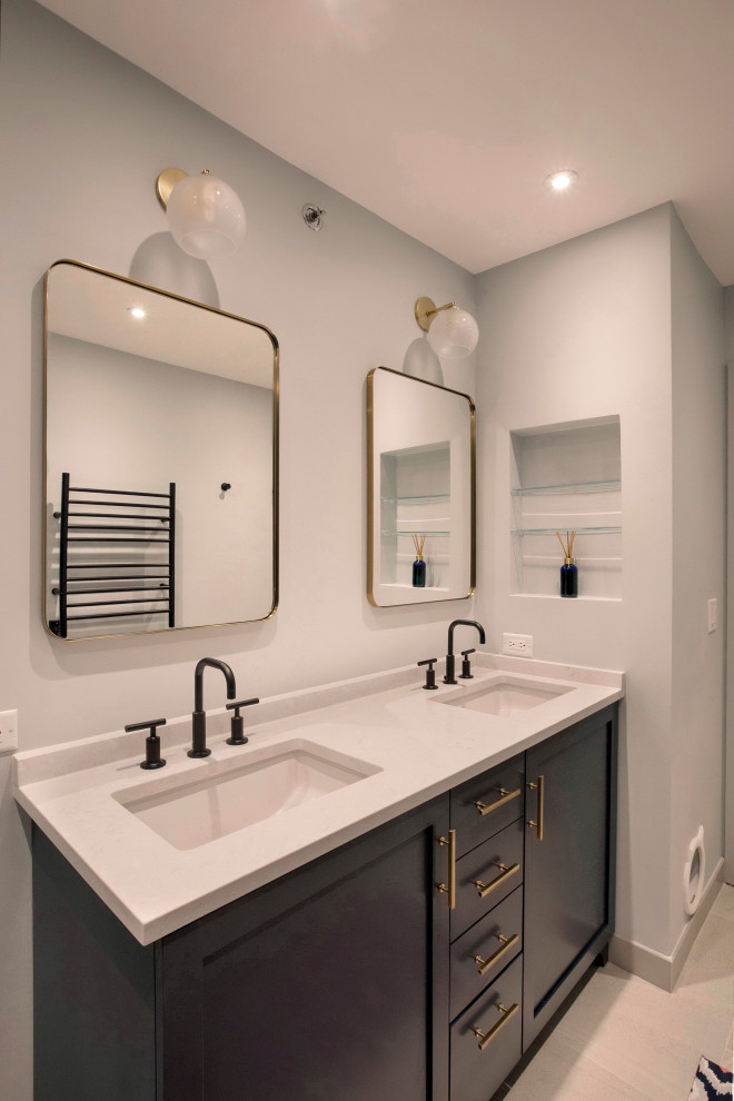 Inspiration for a mid-sized transitional master blue tile and porcelain tile concrete floor, beige floor and double-sink bathroom remodel in Chicago with raised-panel cabinets, blue cabinets, a two-piece toilet, blue walls, an undermount sink, quartzite countertops, a hinged shower door, white countertops and a built-in vanity
