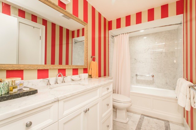 Foto på ett funkis badrum, med skåp i shakerstil, vita skåp, vit kakel, stenkakel, röda väggar, marmorgolv, ett undermonterad handfat och marmorbänkskiva