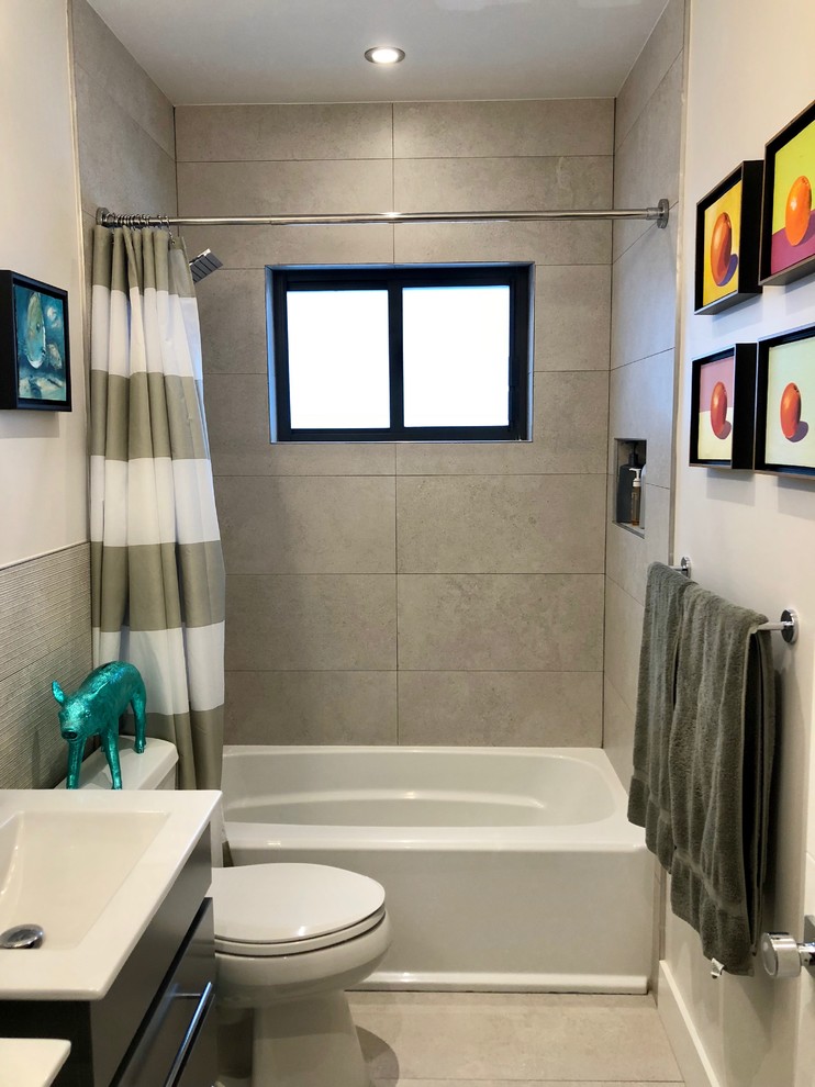 Inspiration for a small transitional kids' gray tile and porcelain tile porcelain tile and gray floor bathroom remodel in Miami with flat-panel cabinets, gray cabinets, a one-piece toilet, white walls, an integrated sink, solid surface countertops and white countertops
