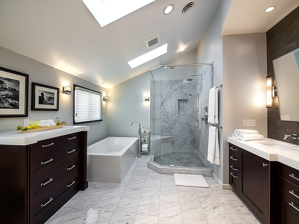 Foto di una grande stanza da bagno contemporanea con lavabo sottopiano, ante in legno bruno, vasca freestanding, doccia ad angolo, WC monopezzo, piastrelle in pietra e pavimento in marmo