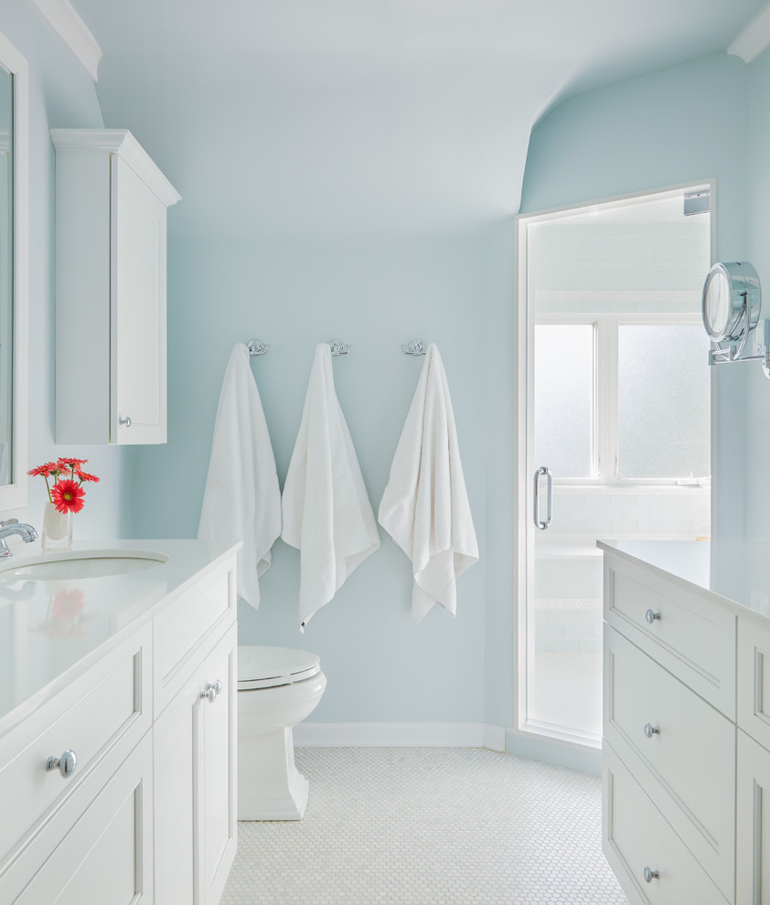 На фото: детская ванная комната среднего размера в стиле неоклассика (современная классика) с врезной раковиной, фасадами с декоративным кантом, белыми фасадами, столешницей из кварцита, душем в нише, унитазом-моноблоком, белой плиткой, стеклянной плиткой, синими стенами и мраморным полом