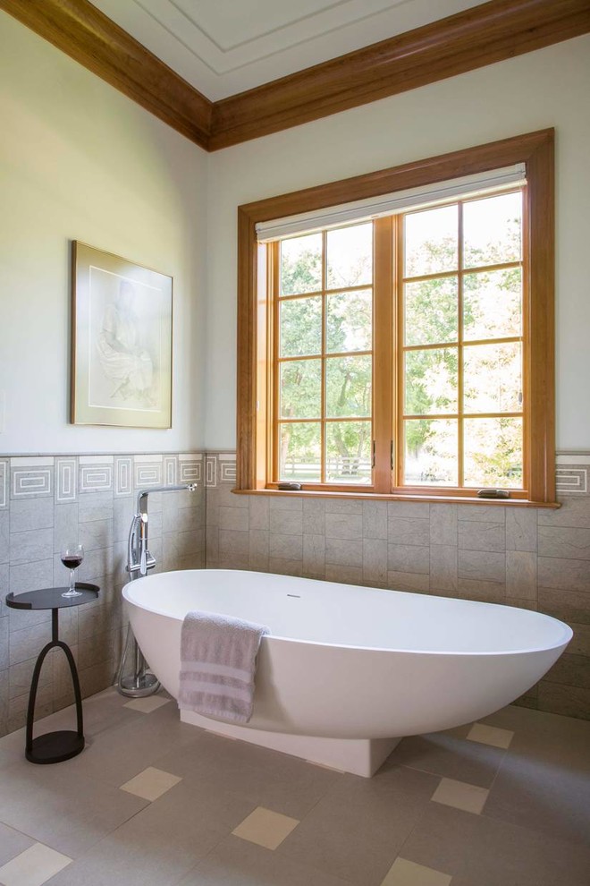 Cette photo montre une salle de bain chic avec une baignoire indépendante, un carrelage multicolore, un mur blanc et une fenêtre.