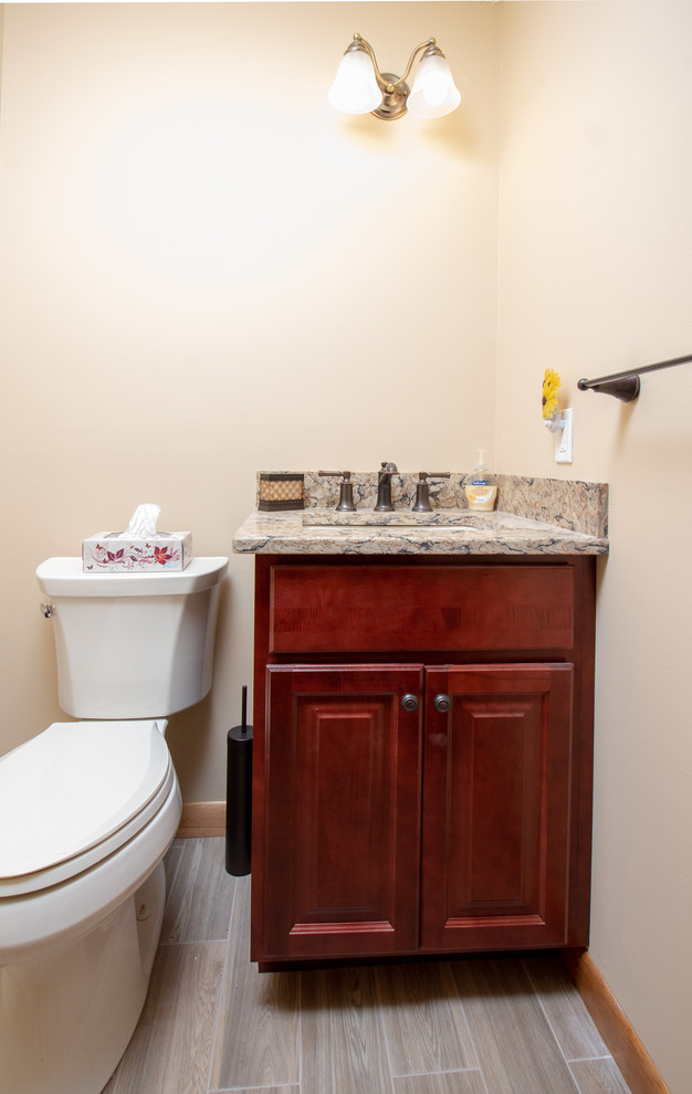 Klassisk inredning av ett litet flerfärgad flerfärgat toalett, med luckor med upphöjd panel, röda skåp, bänkskiva i kvarts, gula väggar, klinkergolv i porslin, ett undermonterad handfat och brunt golv