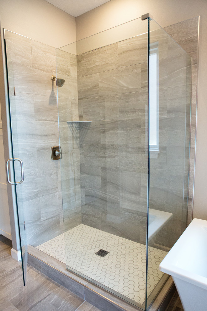 Klassisk inredning av ett stort grå grått en-suite badrum, med släta luckor, vita skåp, ett fristående badkar, en öppen dusch, grå kakel, porslinskakel, grå väggar, klinkergolv i porslin, ett integrerad handfat, bänkskiva i akrylsten, grått golv och med dusch som är öppen