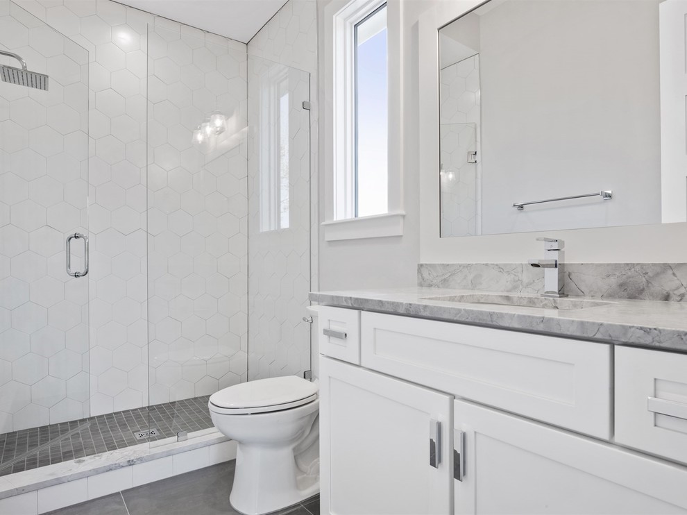 Cette photo montre une petite salle de bain chic avec un placard à porte shaker, des portes de placard blanches, WC séparés, un carrelage blanc, un mur gris, un sol en carrelage de porcelaine, un lavabo encastré, un plan de toilette en marbre, un sol gris, une cabine de douche à porte battante et un plan de toilette gris.