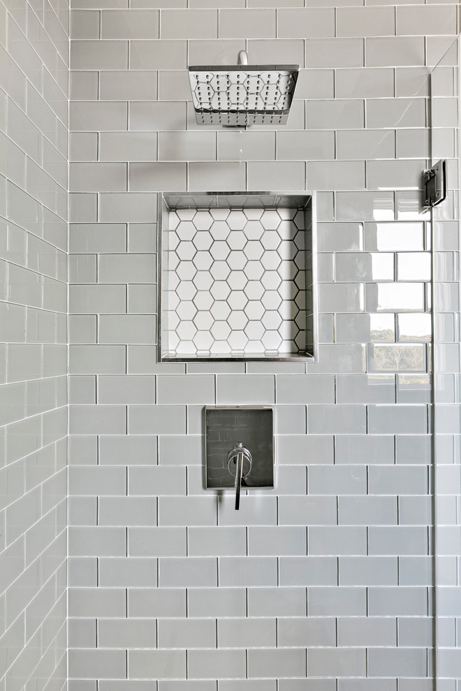 Klassisk inredning av ett mellanstort grå grått badrum med dusch, med skåp i shakerstil, grå skåp, en dusch i en alkov, en toalettstol med hel cisternkåpa, grå kakel, tunnelbanekakel, grå väggar, klinkergolv i keramik, ett undermonterad handfat, marmorbänkskiva, vitt golv och dusch med gångjärnsdörr