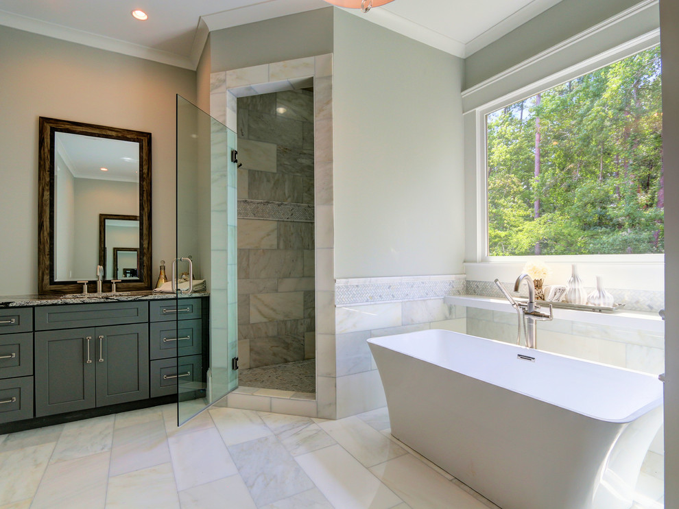 Klassisk inredning av ett mellanstort en-suite badrum, med skåp i shakerstil, blå skåp, ett fristående badkar, en dusch i en alkov, grå kakel, flerfärgad kakel, vit kakel, stenkakel, grå väggar, marmorgolv, ett undermonterad handfat och granitbänkskiva