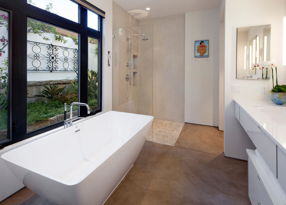 Bathroom - mid-sized mediterranean master beige tile and stone tile concrete floor bathroom idea in Santa Barbara with an undermount sink, flat-panel cabinets, white cabinets, marble countertops, a one-piece toilet and white walls