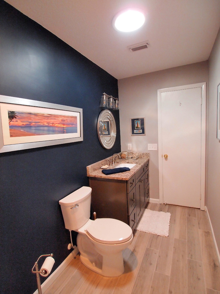 Kleine Klassische Gästetoilette mit Schrankfronten im Shaker-Stil, grauen Schränken, Toilette mit Aufsatzspülkasten, weißen Fliesen, Mosaikfliesen, blauer Wandfarbe, Vinylboden, Unterbauwaschbecken und Granit-Waschbecken/Waschtisch in Jacksonville