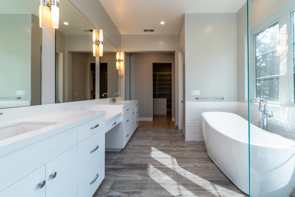 Large traditional ensuite bathroom in San Francisco with flat-panel cabinets, white cabinets, a freestanding bath, a built-in shower, a one-piece toilet, white tiles, porcelain tiles, grey walls, porcelain flooring, a submerged sink, engineered stone worktops, grey floors, a hinged door and white worktops.