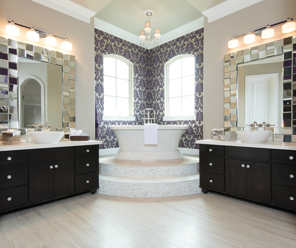 Cette image montre une salle de bain traditionnelle avec une vasque, un placard avec porte à panneau encastré, des portes de placard noires, une baignoire indépendante et un mur marron.