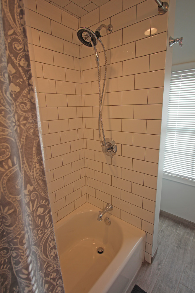 Bild på ett litet vintage flerfärgad flerfärgat badrum för barn, med skåp i shakerstil, grå skåp, ett badkar i en alkov, en dusch/badkar-kombination, en toalettstol med separat cisternkåpa, vit kakel, porslinskakel, vita väggar, klinkergolv i porslin, ett undermonterad handfat, bänkskiva i kvarts, brunt golv och dusch med duschdraperi