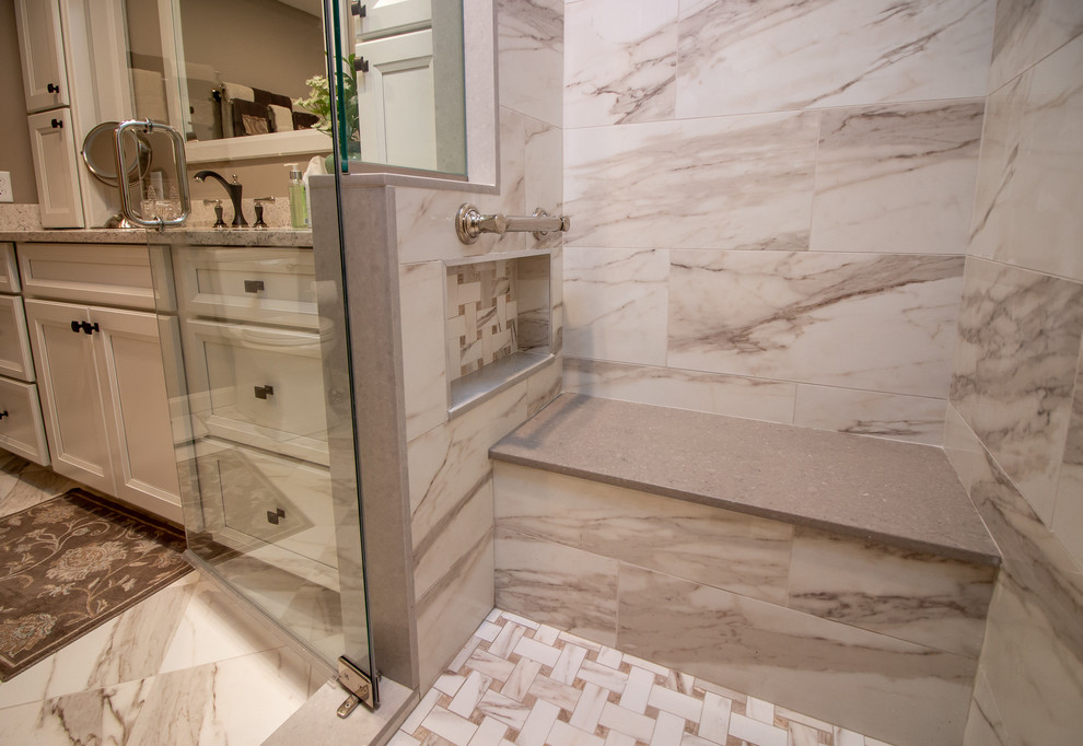 Inspiration for a mid-sized transitional master beige tile and porcelain tile porcelain tile and brown floor alcove shower remodel in Manchester with recessed-panel cabinets, white cabinets, a two-piece toilet, brown walls, a drop-in sink, quartz countertops, a hinged shower door and beige countertops