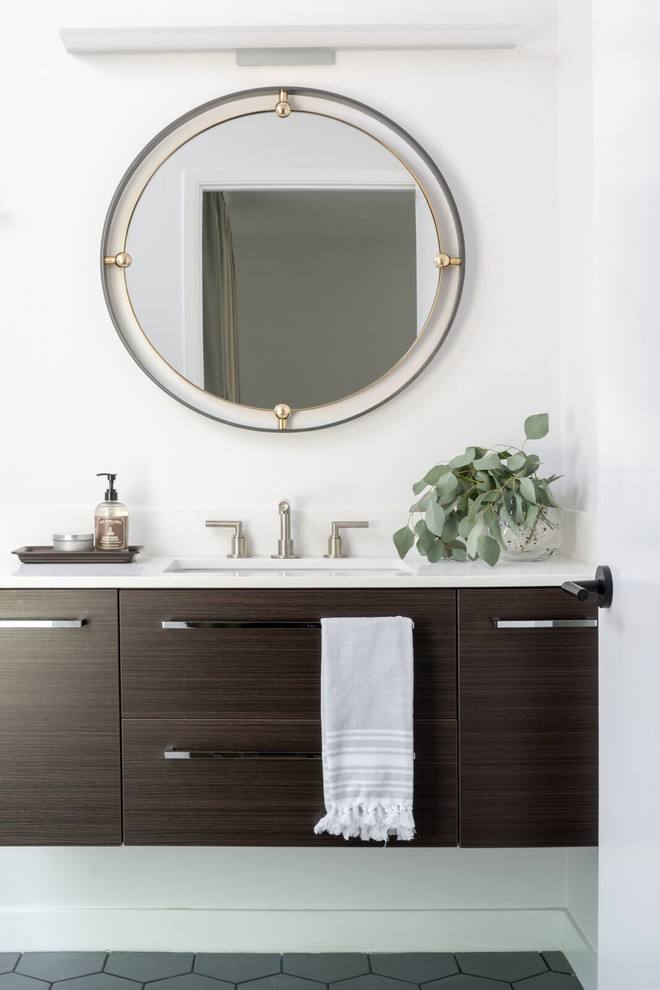 Modelo de cuarto de baño tradicional renovado con armarios con paneles lisos, puertas de armario de madera en tonos medios, paredes blancas, lavabo bajoencimera, suelo gris y encimeras blancas