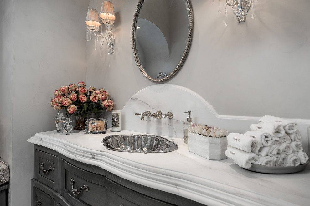 Idéer för att renovera ett mycket stort shabby chic-inspirerat vit vitt badrum med dusch, med skåp i ljust trä, ett fristående badkar, en öppen dusch, en toalettstol med separat cisternkåpa, vit kakel, marmorkakel, klinkergolv i porslin, marmorbänkskiva, vitt golv, dusch med gångjärnsdörr, möbel-liknande, grå väggar och ett nedsänkt handfat