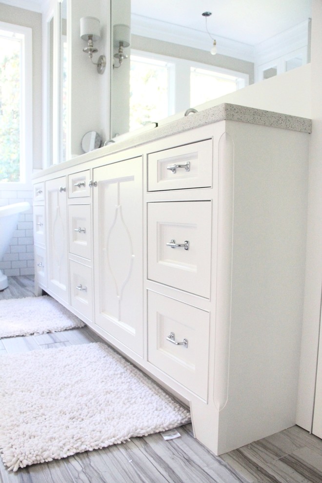 Modelo de cuarto de baño tradicional renovado con lavabo bajoencimera, puertas de armario blancas, encimera de cuarcita, bañera exenta, baldosas y/o azulejos grises y paredes beige