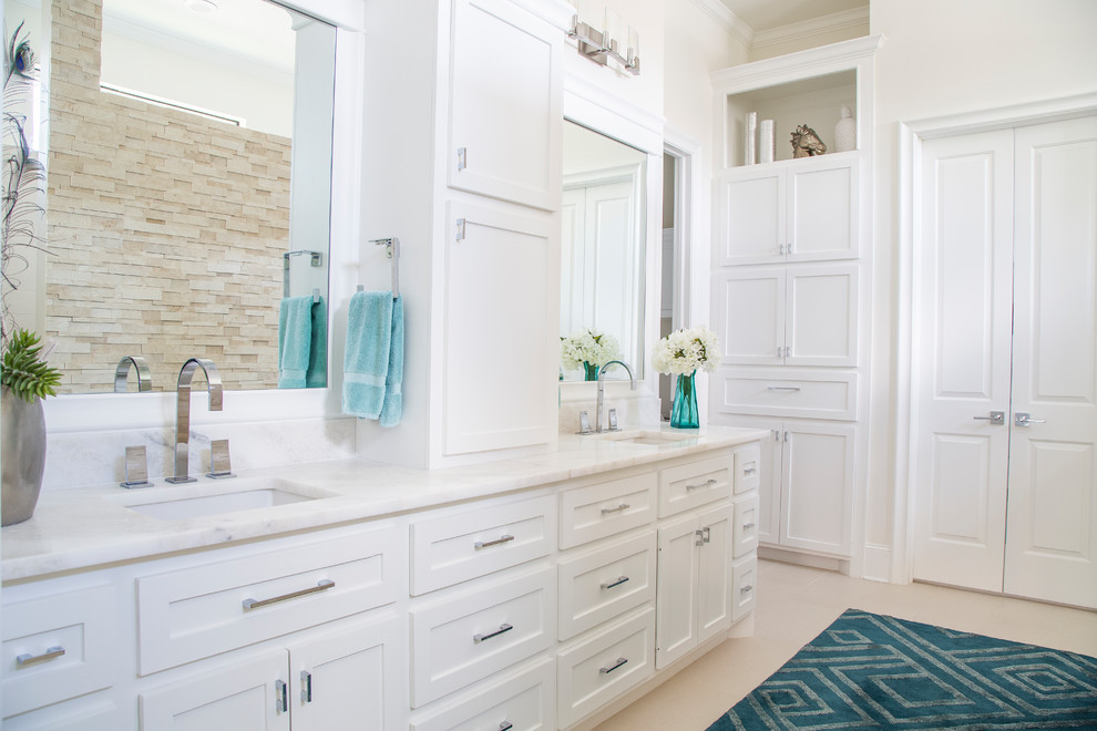 Mid-sized transitional master beige tile and stone tile porcelain tile, beige floor and double-sink bathroom photo in Other with shaker cabinets, white cabinets, a two-piece toilet, white walls, an undermount sink, marble countertops and white countertops