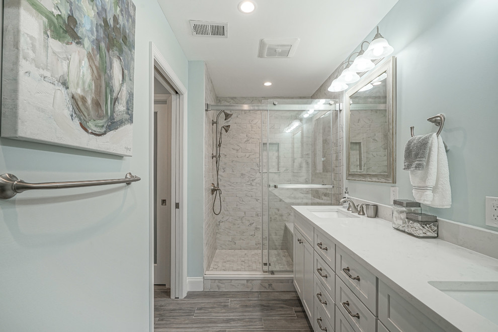 Ejemplo de cuarto de baño principal clásico renovado grande con puertas de armario blancas, paredes azules, ducha con puerta con bisagras y encimeras blancas