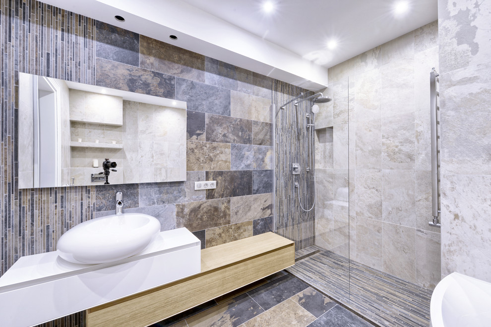 Photo of a medium sized classic ensuite bathroom in Los Angeles with a walk-in shower, a wall mounted toilet, beige tiles, travertine tiles, multi-coloured walls, travertine flooring, a vessel sink, engineered stone worktops, multi-coloured floors, an open shower and multi-coloured worktops.