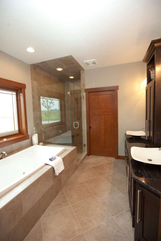 Modelo de cuarto de baño principal tradicional renovado grande con lavabo sobreencimera, bañera encastrada, ducha esquinera, baldosas y/o azulejos grises, baldosas y/o azulejos de porcelana, paredes grises y suelo de baldosas de porcelana