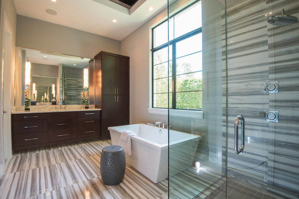 Inspiration for a large transitional master gray tile ceramic tile and gray floor bathroom remodel in Orlando with shaker cabinets, brown cabinets, a bidet, gray walls, a drop-in sink, marble countertops, a hinged shower door and gray countertops