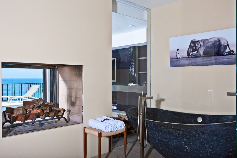Foto di una grande stanza da bagno padronale minimal con vasca freestanding, pareti beige e pavimento in pietra calcarea