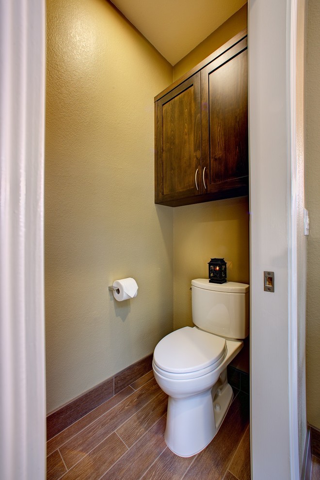 Inspiration pour un WC et toilettes traditionnel en bois foncé avec un placard à porte shaker, WC séparés, un carrelage marron, des carreaux de porcelaine, un mur beige et un sol en carrelage de porcelaine.
