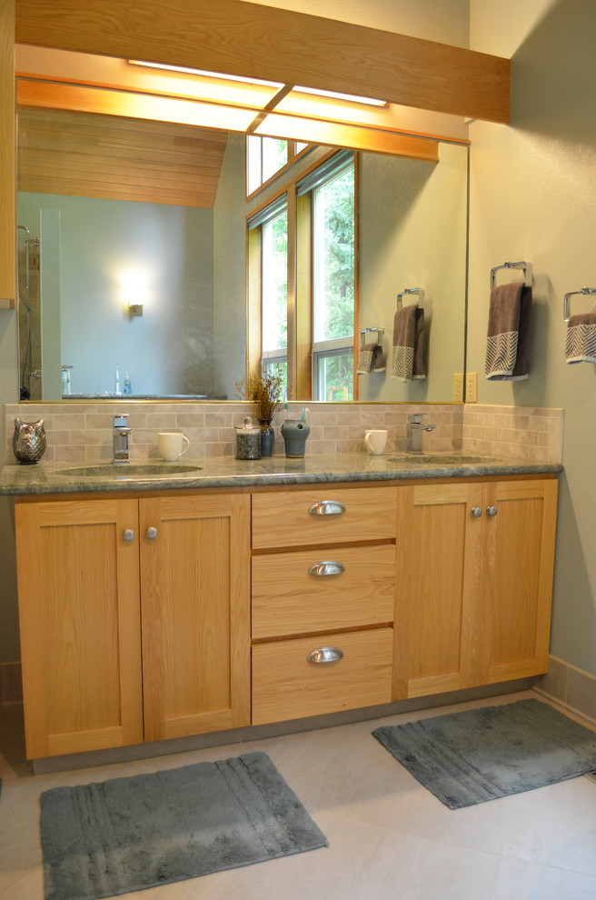 Exempel på ett mellanstort klassiskt en-suite badrum, med skåp i shakerstil, skåp i ljust trä, ett fristående badkar, en dusch i en alkov, en toalettstol med hel cisternkåpa, grå kakel, porslinskakel, blå väggar, klinkergolv i porslin, ett undermonterad handfat, granitbänkskiva, beiget golv och dusch med gångjärnsdörr