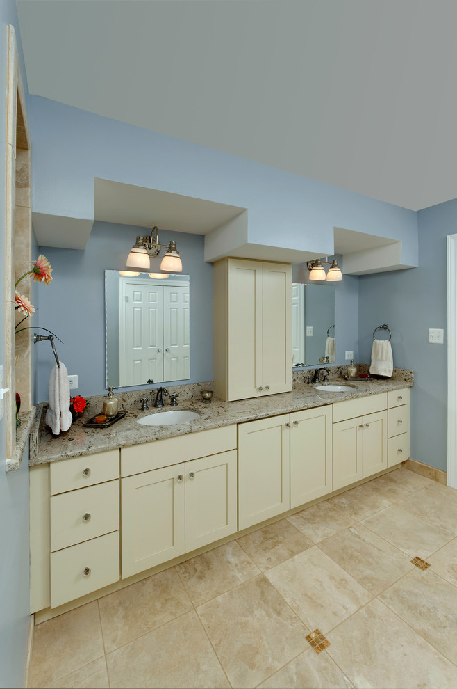 Aménagement d'une grande salle de bain principale contemporaine avec un placard à porte shaker, des portes de placard beiges, une baignoire indépendante, un mur bleu, un sol en carrelage de céramique, un lavabo encastré, un plan de toilette en granite et un sol beige.